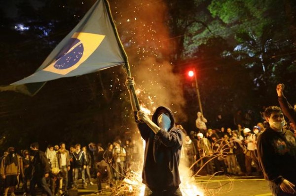 A Protester Holding the Brazilian Flag in the Middle of Tear Gas Stench.