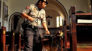 A policeman with a bomb sniffing dog inspects a church in the East Java city of Surabaya in September, 2011, following a suicide bomber attack targeting Christians in the Central Java city of Solo.  AFP photo