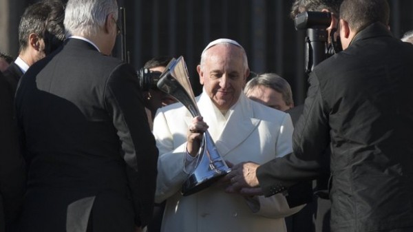 Photo Credit: AP. Pope Francis Receives a Replica Argentinean Championship Trophy from a Small Group of San Lorenzo's Managers and Players on the Step of the St. Peter Basilica. 