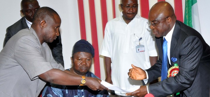 PRESIDENT OF ASUU, DR ISA FAGGE (L), PRESENTING SIGNED AGREEMENT BETWEEN ASUU AND FG TO THE SENATE PRESIDENT DAVID MARK, DURING ASUU LEADERSHIP VISIT TO THE SENATE  IN ABUJA ON THURSDAY (19/12/13). WITH THEM IS ASUU VICE PRESIDENT, PROF. BIODUN OGUNYEMI (NAN).