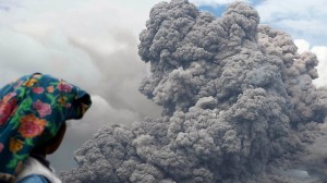 Indonesian villager watches as Mt Sinabung spews hot ash into the air. More than 26,000 people have been forced to flee the volcano.  Picture: AFP