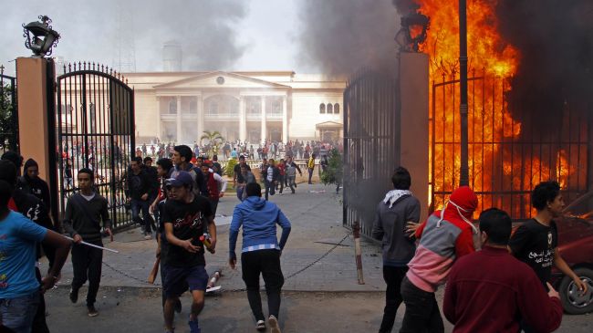 AL-AHLY CLUB SUPPORTERS RUN AWAY FROM THE FLAMES RISING FROM THE POLICE OFFICERS' CLUB IN THE EGYPTIAN CAPITAL, CAIRO 