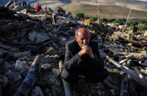 A victim of earthquake sits on the ruins of buildings at the village of Bajebaj near the city of Varzaqan in northwestern Iran, Sunday, Aug. 12, 2012