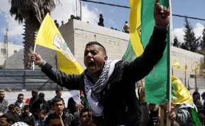 A Palestinian shouts as he holds a Fatah flag during the funeral of Abu Hamdeya in Hebron
