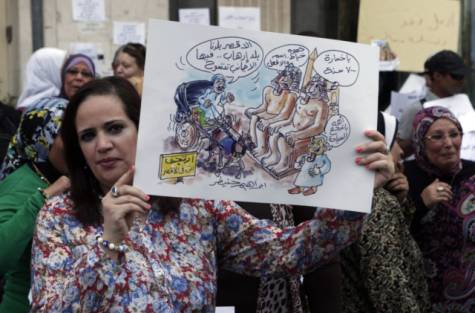 An Egyptian tourism worker holds a placard with a caricature of Luxor temples site denouncing the choice of Adel Asaad Al Khayat as new Governor of Luxor during June 20 protest in front of the Tourism Ministry building in Cairo.