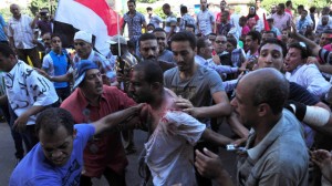 A wounded man is helped following clashes in Alexandria