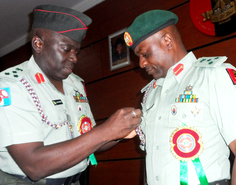 FORMER DIRECTOR, NIGERIAN ARMY PUBLIC RELATIONS, BRIG.-GEN. IBRAHIM ATTAHIRU (L), DECORATING HIS SUCCESSOR, BRIG.-GEN. OLAJIDE LALEYE, WITH THE BADGE OF THE DIRECTORATE DURING THE HAND-OVER CEREMONY IN ABUJA ON TUESDAY (7/1/14). 