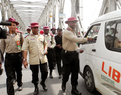 CORPS MARSHAL, FRSC, MR OSITA CHIDOKA (R), OFFICERS AND MEN OF THE CORPS, DISTRIBUTING LEAFLETS WITH ROAD SAFETY MESSAGES TO MOTORISTS ON THE RIVER NIGER BIDGE IN ONITSHA, ANAMBRA ON NEW YEAR'S DAY