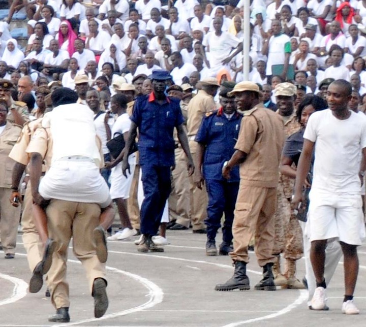 AN OFFICIAL OF THE NIGERIAN IMMIGRATION SERVICE CARRYING ON HIS BACK, A FAINTED FEMALE APPLICANT DURING THE SERVICE'S RECRUITMENT IN IBADAN ON SATURDAY (15/3/14).