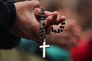 A-woman-holds-rosary-beads-and-crucifix