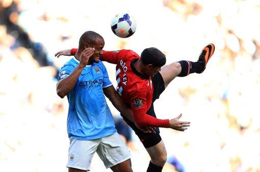 Wayne Roone and Vincent Kompany Contest for a Aerial Ball in a Premier League Match at the Etihad. Image: Getty.