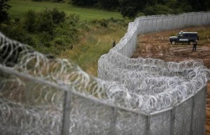 Bulgarian border police stand near a barbed wire fence on the Bulgarian-Turkish border