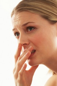 Young woman covering mouth with hand, close-up