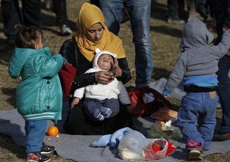 70 Migrants woman holds a child at a migrant center near the village of Adasevci